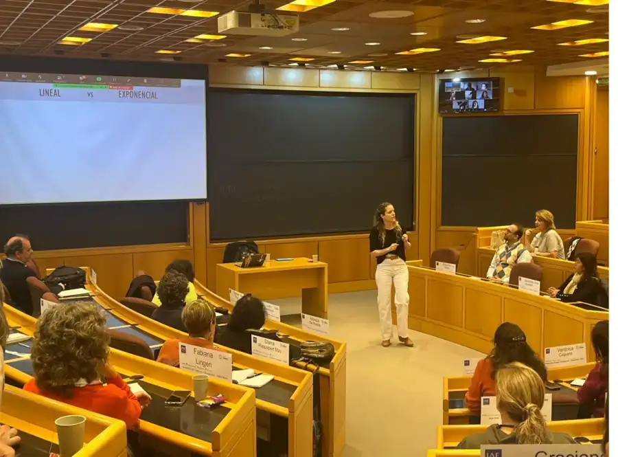 Encuentro de formación en un auditorio con participantes y una presentación.
