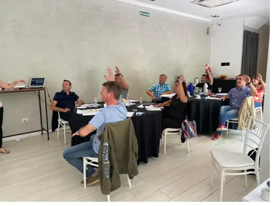 Personas conversando alrededor de una mesa durante una reunión facilitada.