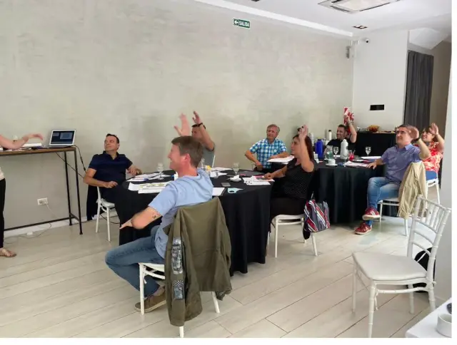 Participantes reunidos alrededor de una mesa, conversando durante un encuentro.
