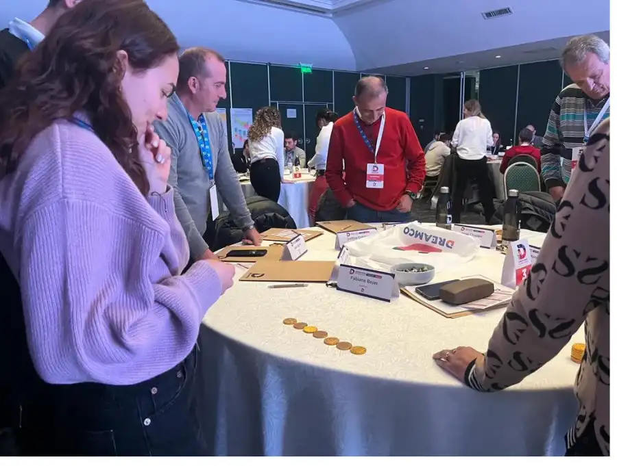 Grupo conversando y trabajando con materiales en una mesa de taller.