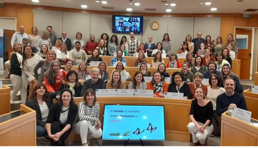 Foto grupal de participantes de un encuentro en un auditorio.