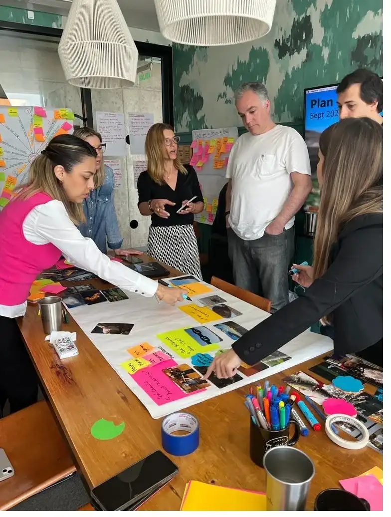 Equipo organizando notas adhesivas y tarjetas sobre una mesa.